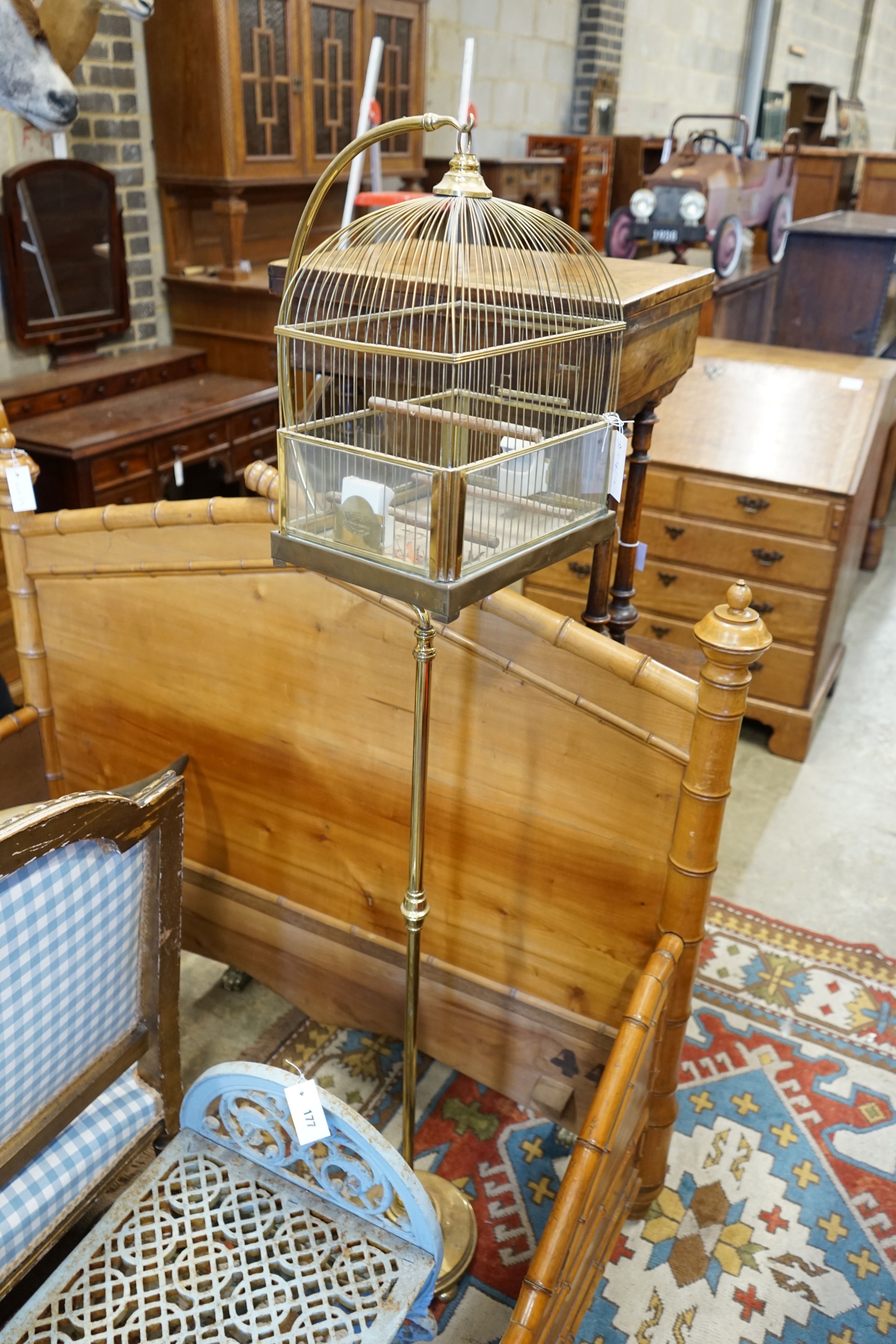 A brass ‘GenyKage’ canary cage on telescopic brass stand, width 31cm depth 23cm height 162cm